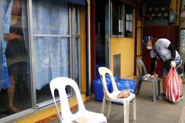 Antipolo Şehri, Filipinler - 23 Nisan 2020: Hükümet çalışanları yardım ürünleri dağıtıyor ve Covid 19 virüs salgını sırasında insanlarla temastan kaçınmak için evlerin önüne bırakıyorlar..