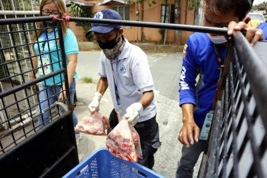 Antipolo Şehri, Filipinler - 23 Nisan 2020: Hükümet çalışanları yardım ürünleri dağıtıyor ve Covid 19 virüs salgını sırasında insanlarla temastan kaçınmak için evlerin önüne bırakıyorlar..