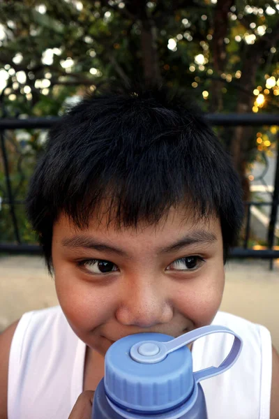 Photo Beau Garçon Asiatique Tenant Une Bouteille Eau Près Son — Photo