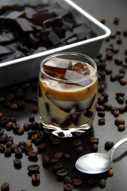 Kahve aromalı jöle fotoğrafı. Masadaki temiz bardakta süt var..