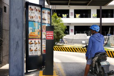 Antipolo Şehri, Filipinler - 5 Mayıs 2020: Müşteriler arabaları ve motosikletleriyle Covid 19 virüs salgını sırasında bir fast food restoranının önüne dizildiler.