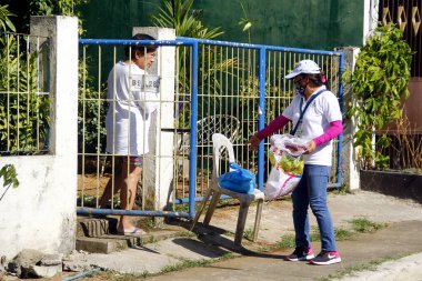 Antipolo Şehri, Filipinler - 11 Mayıs 2020: Yerel hükümet çalışanları ve ulusal polis memurları, Covid 19 virüs salgını nedeniyle tecrit sırasındaki sakinlere yardım ürünleri dağıtıyor.