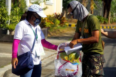 Antipolo Şehri, Filipinler - 11 Mayıs 2020: Yerel hükümet çalışanları ve ulusal polis memurları, Covid 19 virüs salgını nedeniyle tecrit sırasındaki sakinlere yardım ürünleri dağıtıyor.