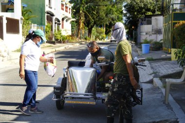 Antipolo Şehri, Filipinler - 11 Mayıs 2020: Yerel hükümet çalışanları ve ulusal polis memurları, Covid 19 virüs salgını nedeniyle tecrit sırasındaki sakinlere yardım ürünleri dağıtıyor.