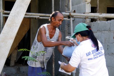 Antipolo Şehri, Filipinler - 11 Mayıs 2020: Yerel hükümet çalışanları ve ulusal polis memurları, Covid 19 virüs salgını nedeniyle tecrit sırasındaki sakinlere yardım ürünleri dağıtıyor.