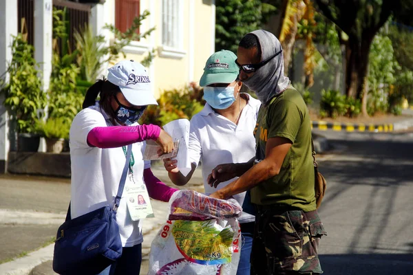 Antipolo Şehri, Filipinler - 11 Mayıs 2020: Yerel hükümet çalışanları ve ulusal polis memurları, Covid 19 virüs salgını nedeniyle tecrit sırasındaki sakinlere yardım ürünleri dağıtıyor.