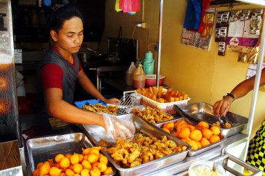Antipolo Şehri, Filipinler - 16 Mayıs 2020: Tedarikçi, Covid 19 virüs salgını nedeniyle iki aylık gelişmiş toplum karantinasının ardından gevşetilmesiyle, tezgahında çeşitli kızarmış yiyecekler servis etmektedir..