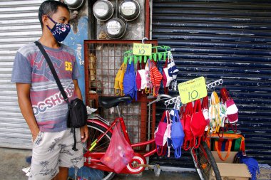 Antipolo Şehri, Filipinler - 16 Mayıs 2020: Sokak satıcısı, Covid 19 virüs salgını sırasında korunmak için yıkanabilir yüz maskesi sattı.