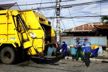 Antipolo Şehri, Filipinler - 16 Mayıs 2020: Çöp toplayıcıları çöp kamyonuna çöp koydu.