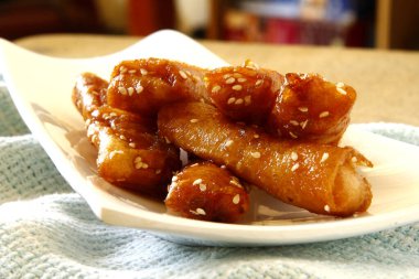 Turon adındaki Filipin yemeklerinin ya da bahar rulosu ambalajında kızartılmış saba muzun esmer şeker ve susam tohumlarıyla fotoğrafı..