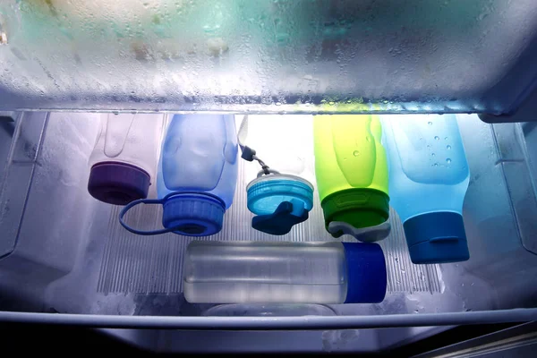 Zdjęcie Plastikowych Pojemników Napoje Wypełnionych Zimną Wodą Schładzaczu Wewnątrz Lodówki — Zdjęcie stockowe