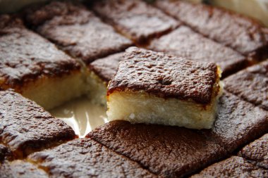 Bibingka Malagkit ya da hindistan cevizi sütüyle pişirilmiş ve üzeri karamelize edilmiş hindistan cevizli pirinçli pirinç keki adı verilen Filipinli atıştırmalıkların fotoğrafı..