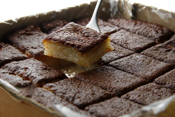 Photo of Filipino snack food called Bibingka Malagkit or rice cake made from glutenous rice cooked in coconut milk and topped with caramelized coconut.