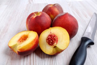 Şeftali ve masanın üzerine siyah bıçak.