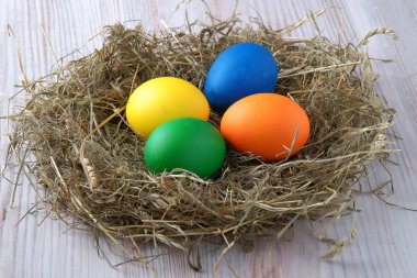 Saman yuvada çok renkli Paskalya yumurtaları vardır. Görünümü kapatın.