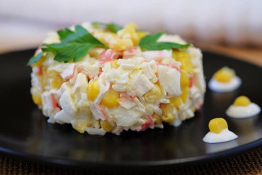 Siyah plaka salata Yengeç sopa, Mısır, haşlanmış pirinç, yumurta ve mayonez ilavesi ile üzerinde. Yemek yeşil maydanoz yaprakları ile dekore edilmiştir. Görünümü kapatın. 