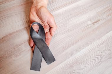 Bir kadının elini tut Parkinson hastalığı bilincini bir gri şerit. Parkinson gün sembolü olarak. 