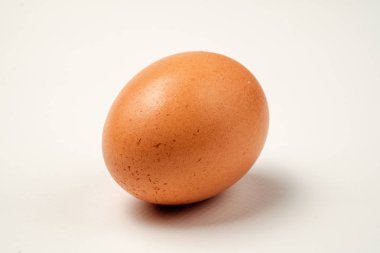 Tek kahverengi tavuk yumurta beyaz bir yüzeye.