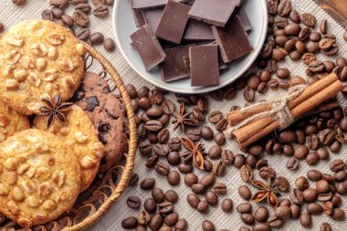 Çikolata Çerezler ve hasır sepet ve fincan tabağı çikolata parçaları ile fıstık çerezleri fişleri. Yakın çekim görünümü.