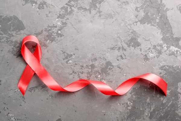 具体的な背景に赤いリボン。12月1日世界エイズデー、 HIV感染者キャンペーン. — ストック写真