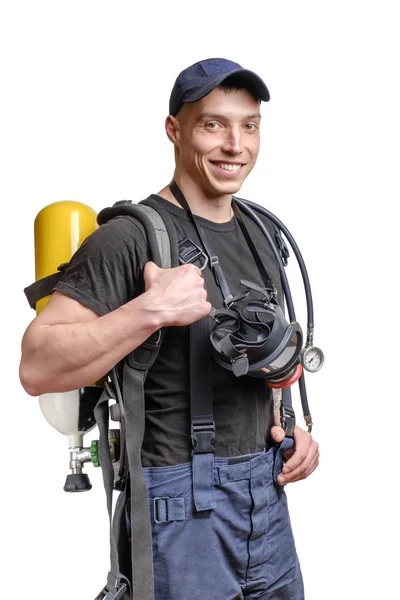 Молодой улыбающийся пожарный в маске и воздушной упаковке на спине в черной футболке — стоковое фото
