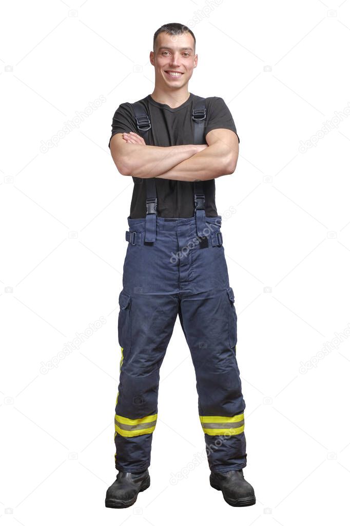 Young smiling firefighter with folded arms wearing black t-shirt and fireproof pants with suspenders.