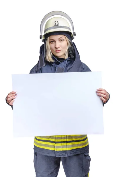 カメラを見て手ぶらで手ぶらで空の紙を持っている制服やヘルメットを身に着けている若い美容消防士. — ストック写真