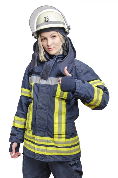 Młoda uśmiechnięta strażaczka w kasku, nosząca ognioodporny mundur, stoi i robi gest w porządku. — Zdjęcie stockowe