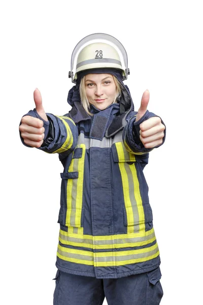 一名身穿防火制服、头戴头盔、面带微笑的年轻消防员女孩站起身来，用双手做了个手势. — 图库照片