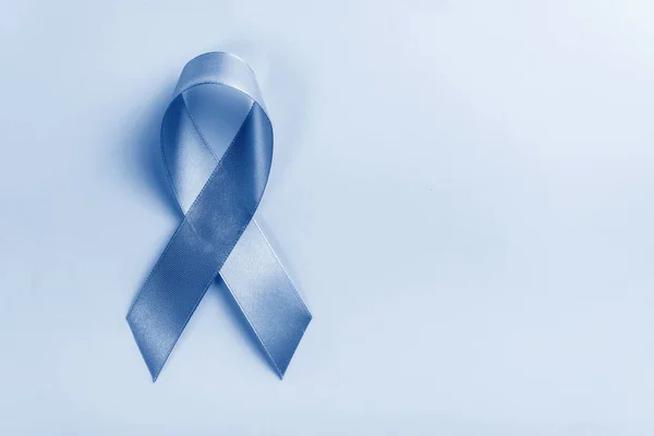 Ribbon painted in trendy color of year 2020 Blue Classic on blue background, prostate cancer awareness concept. — ストック写真