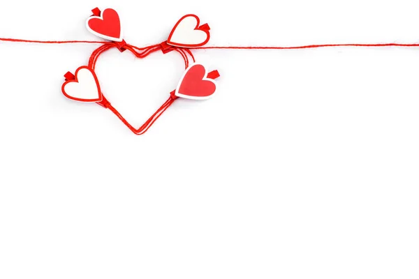 Τυλιγμένο σε κόκκινο σχοινί σε σχήμα καρδιάς με μανταλάκια σε σχήμα καρδιάς που απομονώνονται στο λευκό. Έννοια Ημέρα του Αγίου Βαλεντίνου. — Φωτογραφία Αρχείου