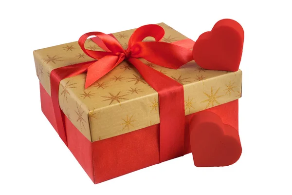 Regalo rojo o caja de regalo con parte superior de color dorado y lazo de cinta roja, dos corazones aislados sobre fondo blanco —  Fotos de Stock