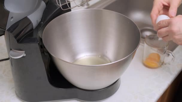 女人的手打破了鸡蛋 将蛋白质和蛋黄分解成食品加工过程中的金属碗 准备烘焙Kiev蛋糕 闭包视图 — 图库视频影像