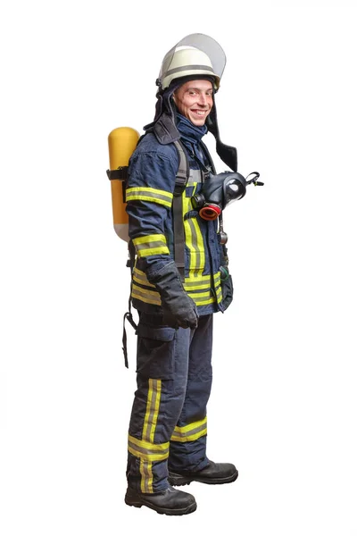 Young fireman with a mask and an air breathing apparatus on his back in a fully protective suit — Stock Photo, Image