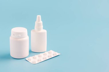 Etiketsiz ve hapsız haplar için iki beyaz plastik şişe.