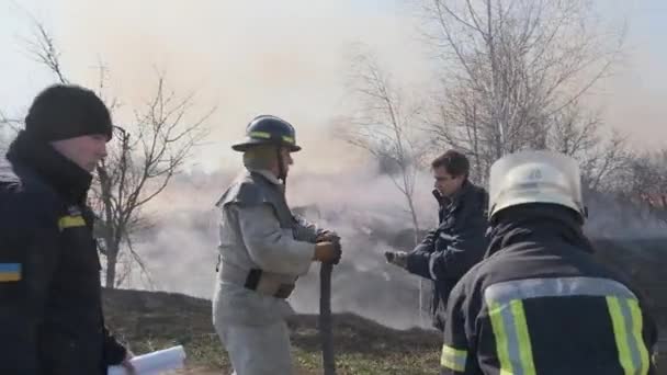 2020年3月20日 2020年3月20日 2人の消防士がドライグラスの消火用エンジンと早春の森林火災用エンジンにホースを接続 — ストック動画
