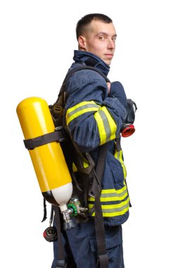 Sırtında Full Facepiece Respirator ve Solunum Hava Silindiri Meclisi ile beyaz arka planda izole edilmiş ateşe dayanıklı üniformayla profilde poz veren beyaz itfaiyeci.