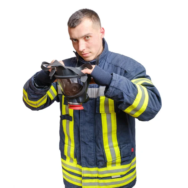 身穿制服的年轻的高加索消防员在他的头上戴上完整的面罩呼吸器 因白人背景而被隔离 — 图库照片