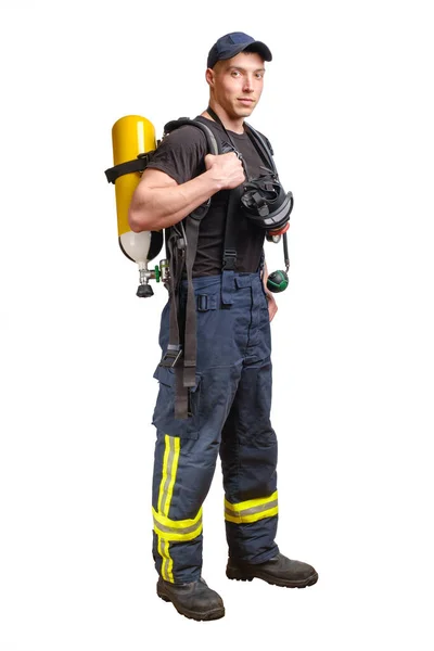 戴着棒球帽 背着呼吸器和空气呼吸器 穿着防护裤 穿着白色背景的黑色T恤的年轻消防员 — 图库照片
