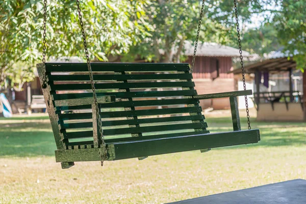 yeşil çim zemin üzerine kahverengi salıncak