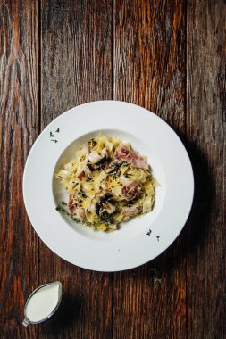 Eski grunge karanlık tablo üzerinde beyaz seramik plaka kremalı mantar soslu makarna spagetti.