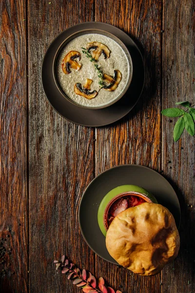 Μανιταρόσουπα κρέμα διακοσμημένα με Ασπρομανίταρα σε φέτες και τοστ στο σκοτεινό ξύλινο τραπέζι. — Φωτογραφία Αρχείου