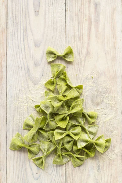 Tészta spenót formájában íjak fa asztalra formájában karácsonyfa Jogdíjmentes Stock Fotók