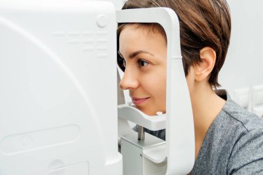 Göz doktoruyla randevusu olan genç bir kadın. Kapat..