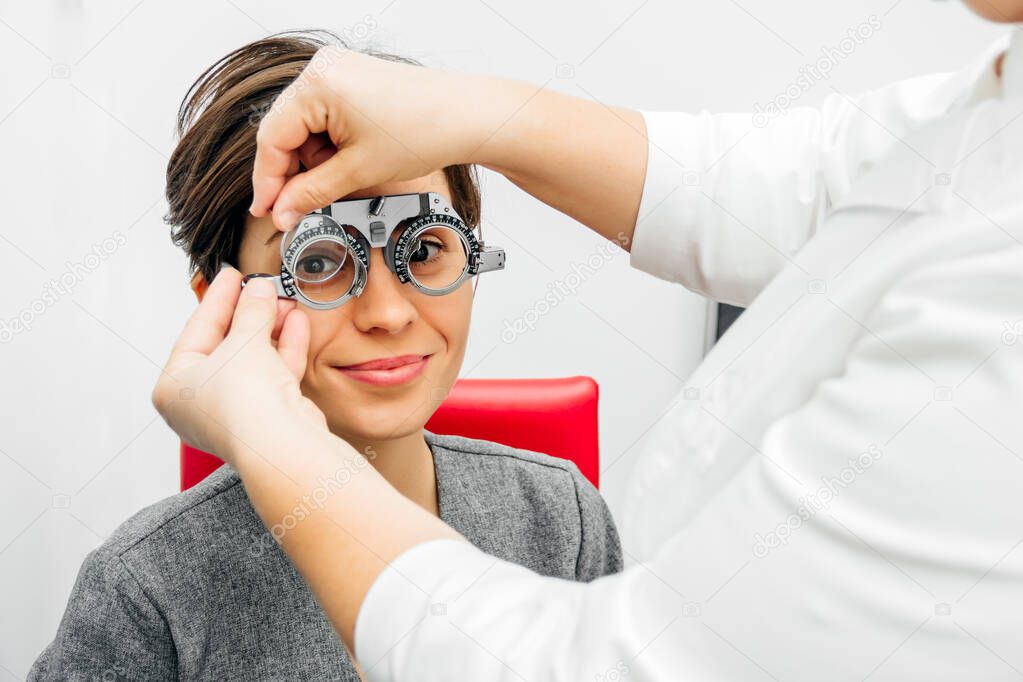 smiling woman in optical trial frame on light gray background