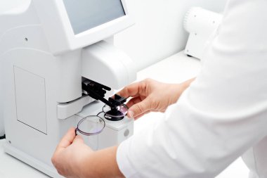 Professional ophthalmology instrument in clinic office and optics.Optician measuring glasses. Optician measuring and preparing glasses.