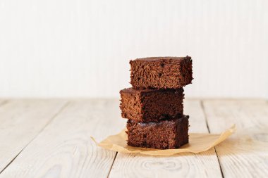Brownie, açık sade ahşap masada çikolatalı kek.