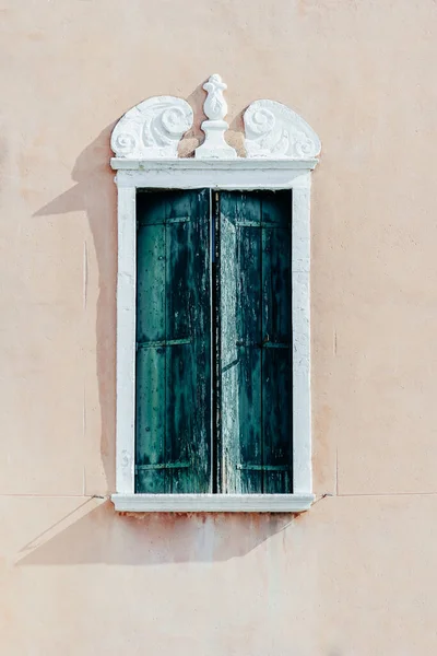 Okno z niebiesko-zielonymi okiennicami na jasnobeżowej ścianie — Zdjęcie stockowe