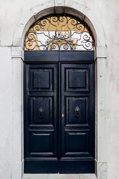 an old dark blue door with handles in the shape of a lions head
