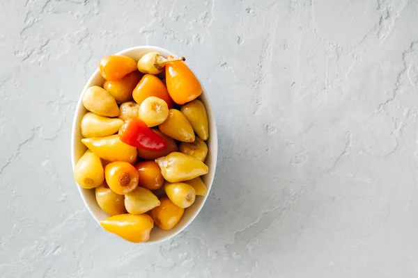 Small pickled hot peppers on a gray concrete background Royalty Free Stock Images